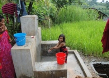 Child is washing her hand in tap